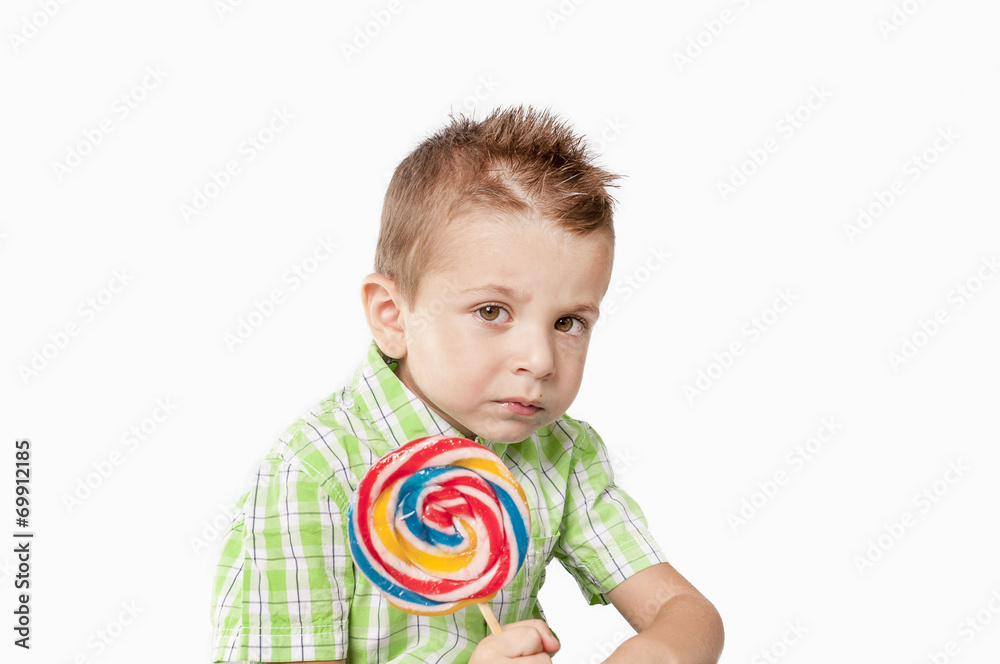 Pensive little boy con lollipop