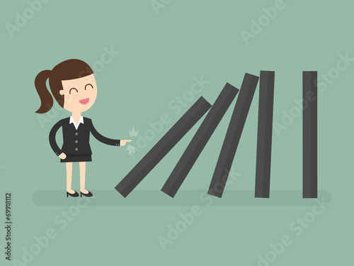 Business woman toppling dominoes. Domino effect.