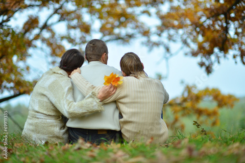 Family sitting in autumn park