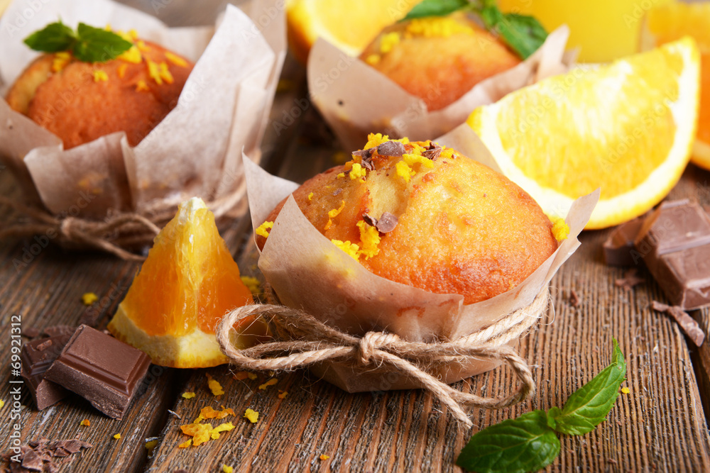 Tasty cupcakes with orange on table close-up Tasty cupcakes with orange on table close-up
