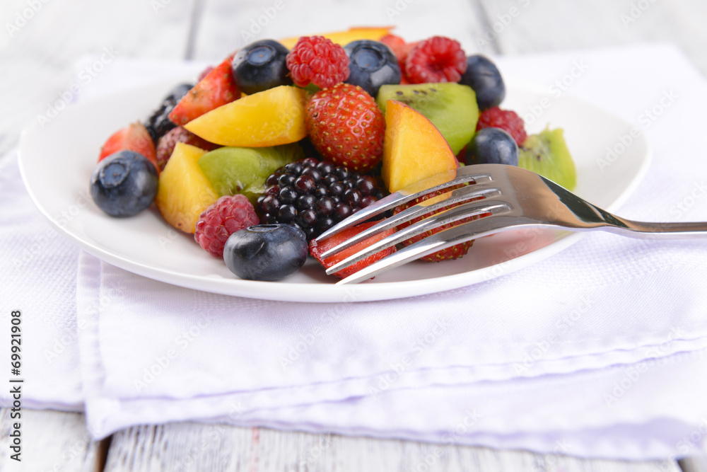 Delicious fruits salad in plate on table close-up Delicious fruits salad in plate on table close-up