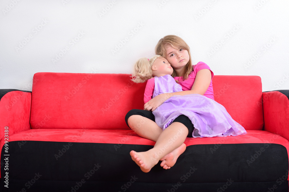 Cute little girl playing with a doll