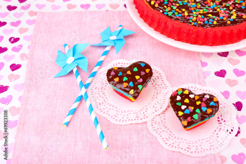 Delicious rainbow cakes on paper napkin, on bright background