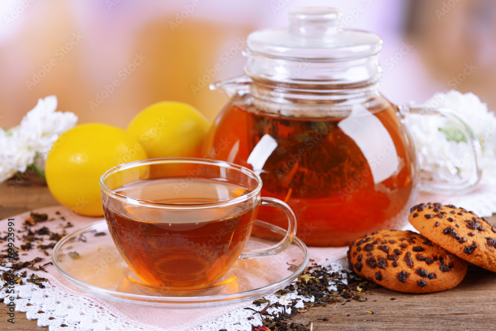 Teapot and cup of tea on table on light background Teapot and cup of tea on table on light background