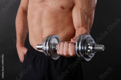 Muscle young sportsman execute exercise with dumbbell
