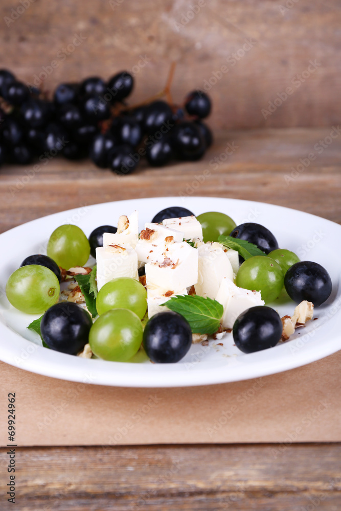 tasty salad with grape and cheese on wooden table tasty salad with grape and cheese on wooden table