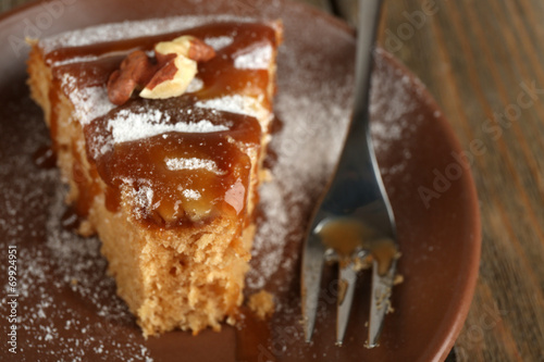 Half eaten delicious cake piece on plate on wooden table