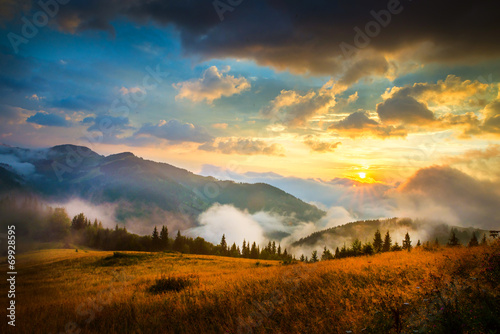 Amazing mountain landscape with fog and a haystack