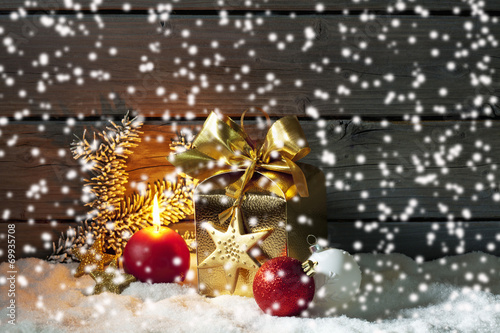 Goldenes Weinachtpäckchen auf Schneehaufen photo