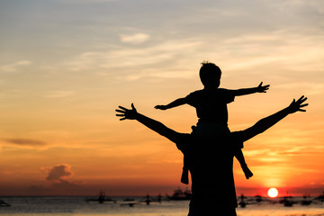 father and son on sunset beach