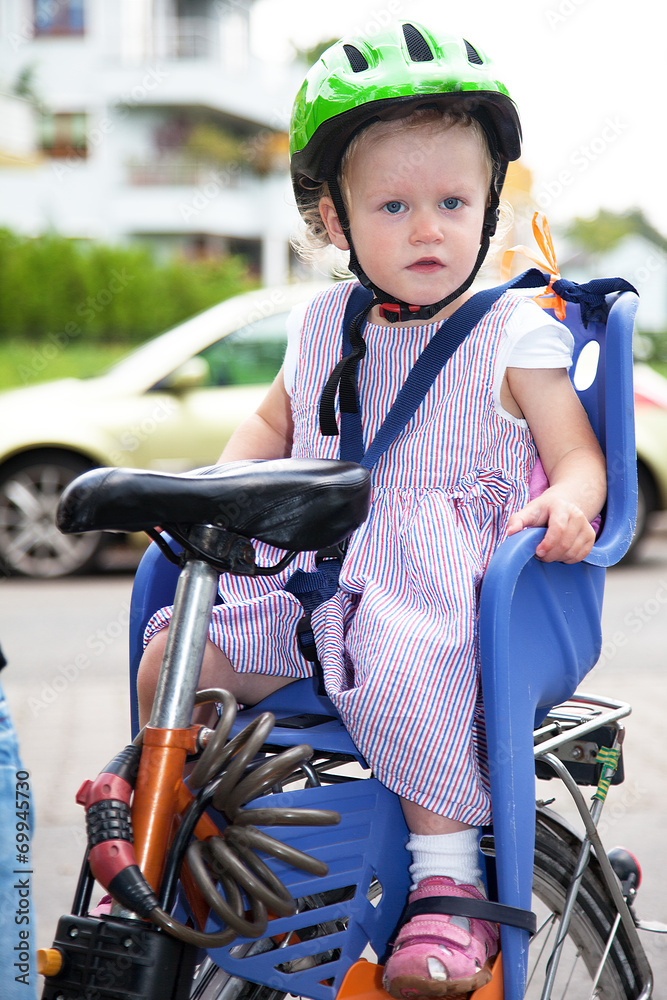 Obraz premium Child sits strapped in the seat bicycle