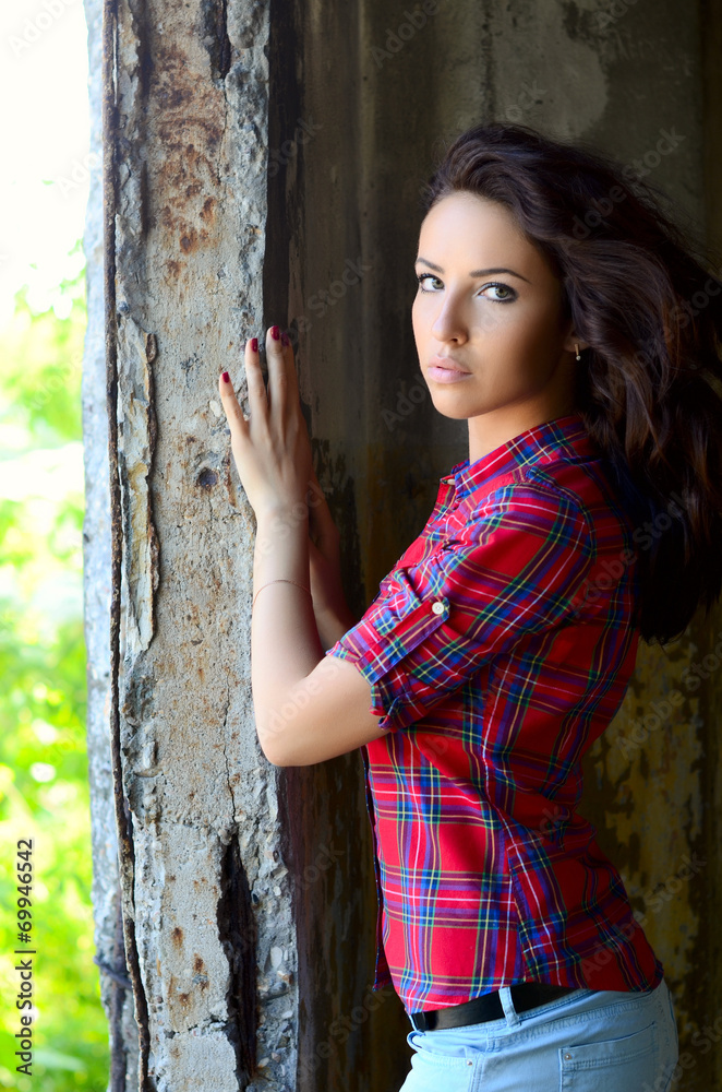 Fototapeta premium The woman against the destroyed old wall