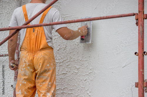 Plasterer applying a finish coating to a wall 3