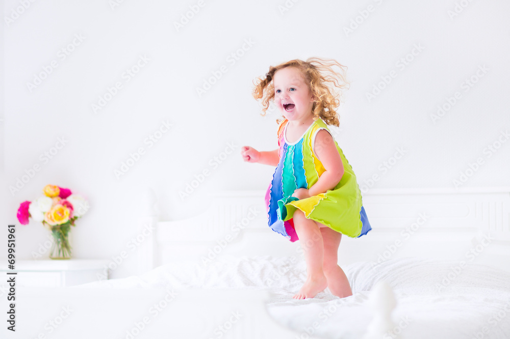 Beautiful little girl jumping on a bed Beautiful little girl jumping on a bed