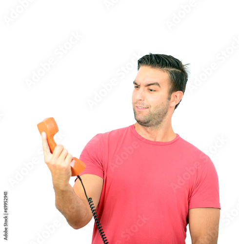 Portrait of young man in shock while talking on phone having unp