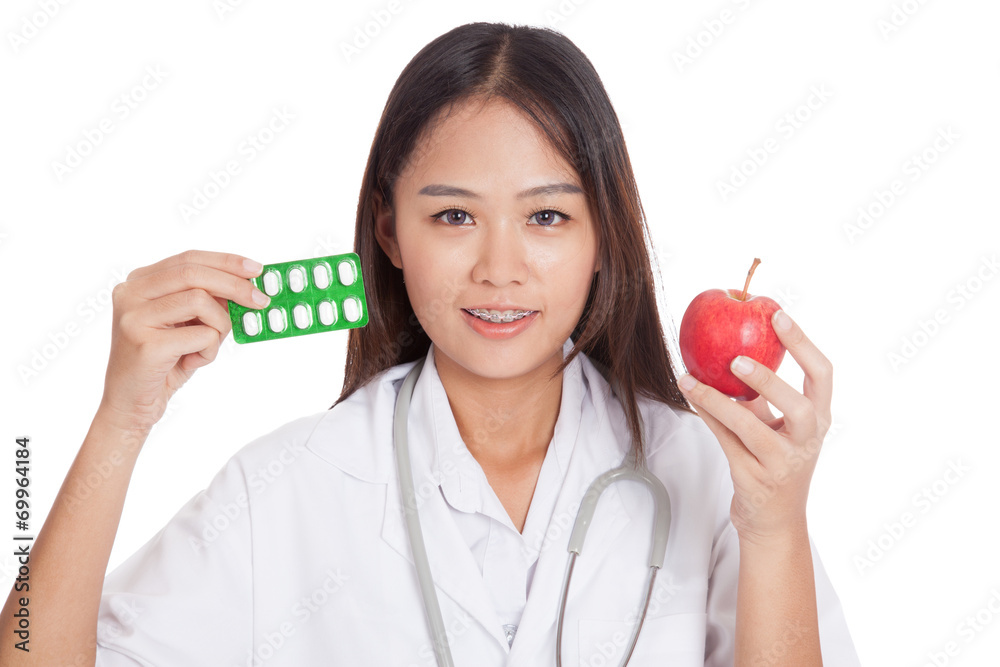 Young Asian female doctor with pills and apple Young Asian female doctor with pills and apple