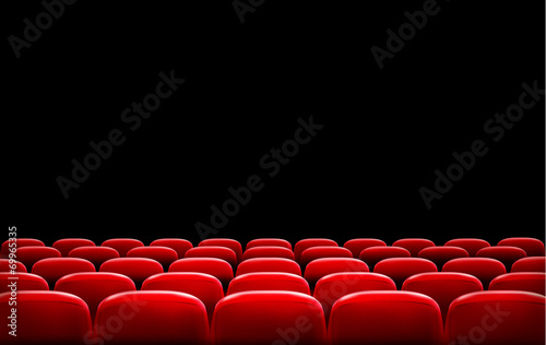 Rows of red cinema or theater seats in front of black screen wit
