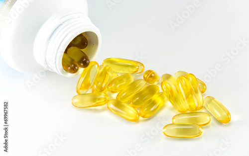 Vitamin Omega-3 fish oil capsules near a bottle