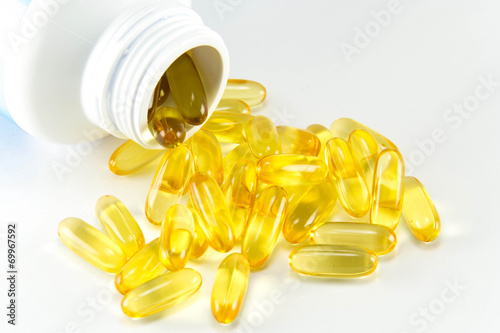 Vitamin Omega-3 fish oil capsules near a bottle