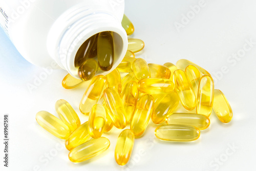 Vitamin Omega-3 fish oil capsules near a bottle