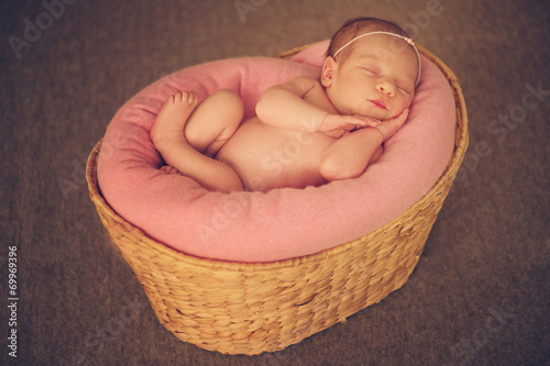 Sleeping Newborn Baby in Basket on Soft Floor