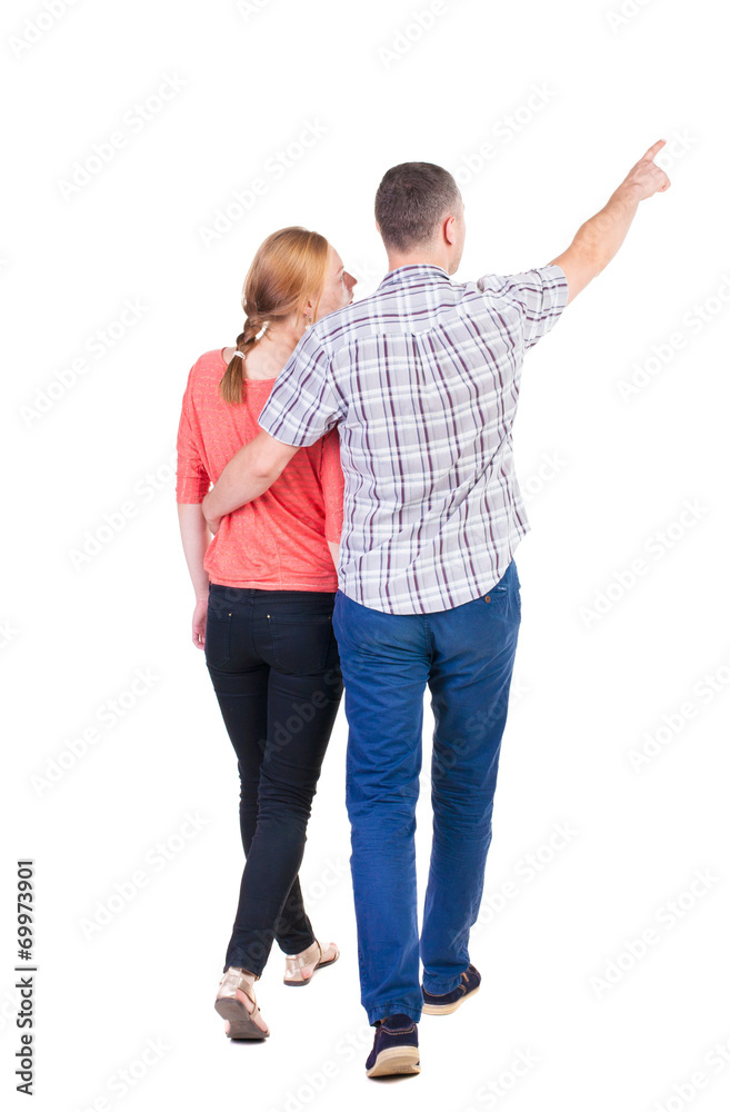 Back view of walking young couple (man and woman) pointing. Back view of walking young couple (man and woman) pointing.