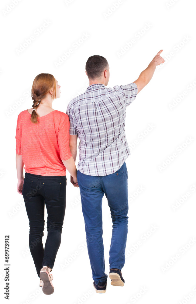 Back view of walking young couple (man and woman) pointing. Back view of walking young couple (man and woman) pointing.