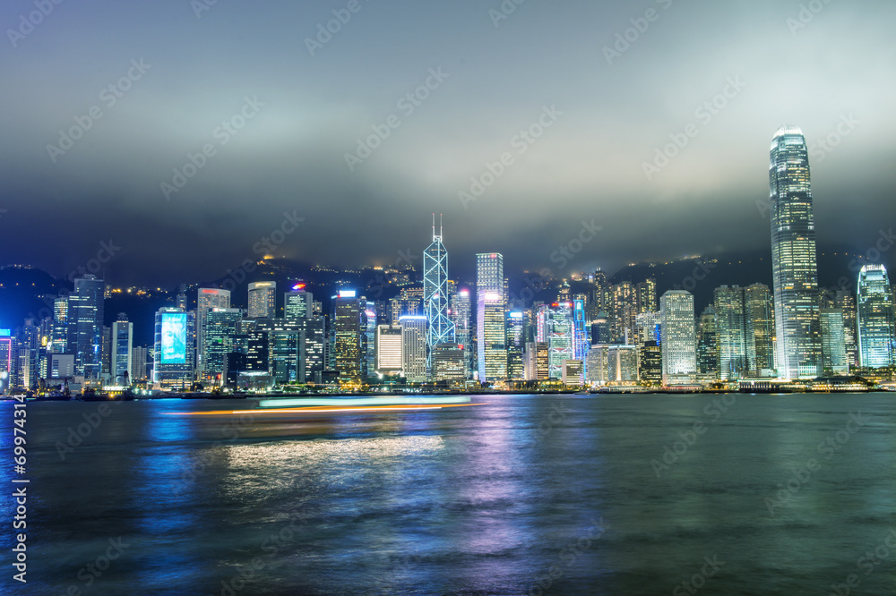 Fototapeta premium Hong Kong. Skyscrapers reflection with boat light trails