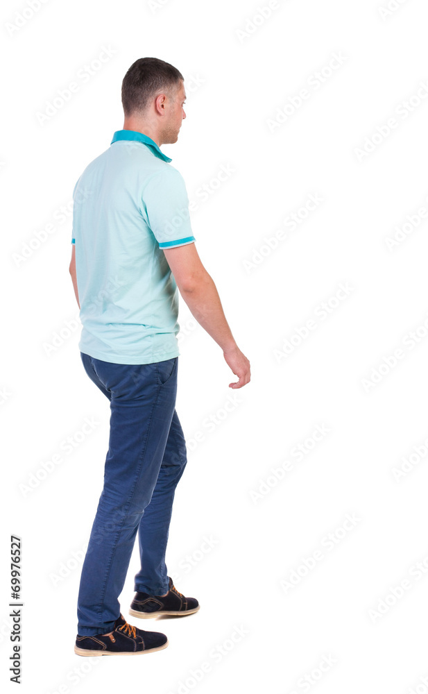 Back view of going handsome man in jeans and a shirt. Back view of going handsome man in jeans and a shirt.