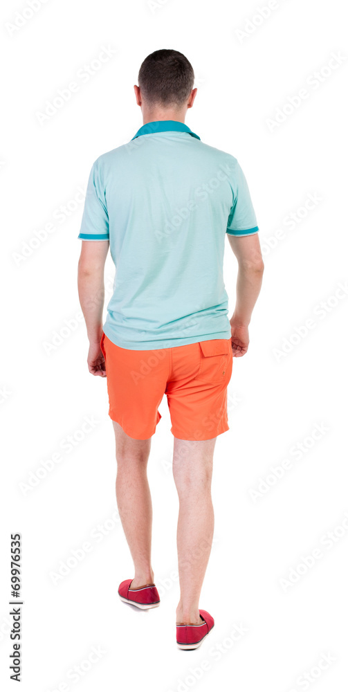 Back view of going handsome man in shorts. walking young guy Back view of going handsome man in shorts. walking young guy