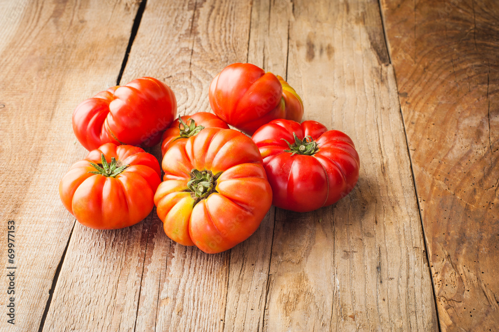 Red big tomatoes on a wooden rustic table in a beautiful day Red big tomatoes on a wooden rustic table in a beautiful day