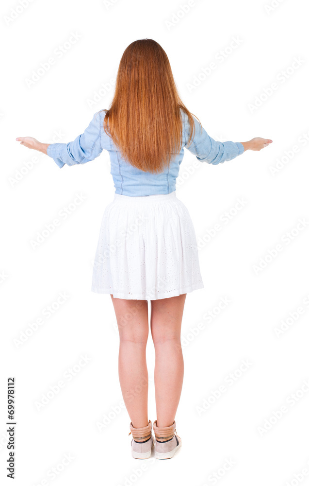 Back view of Beautiful woman in dress looking at wall and Holds Back view of Beautiful woman in dress looking at wall and Holds