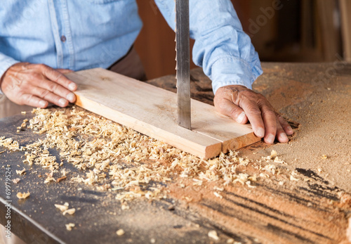 Cropped Image Of Carpenter Cutting Wood With Bandsaw