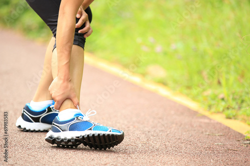 woman runner hold her twisted ankle