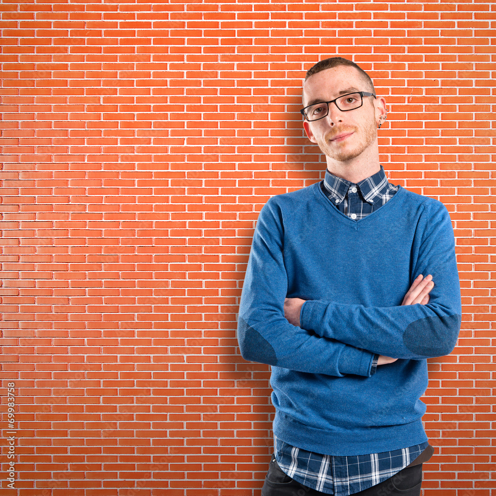 Redhead man with arms crossed over bricks background Redhead man with arms crossed over bricks background