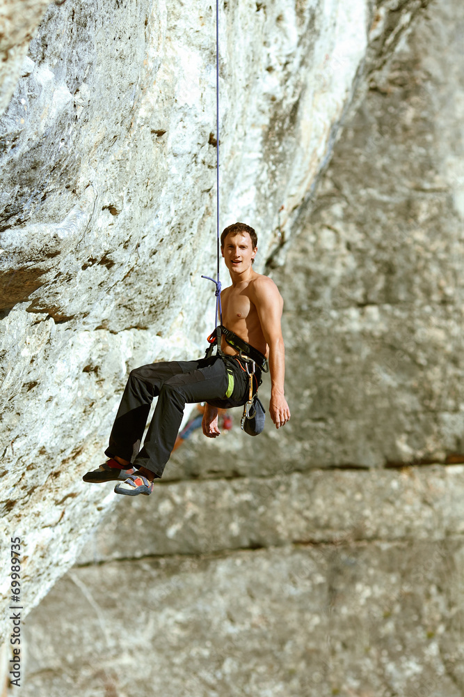 Rock climber climbing up a cliff Rock climber climbing up a cliff
