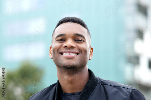 Friendly young man smiling outdoors