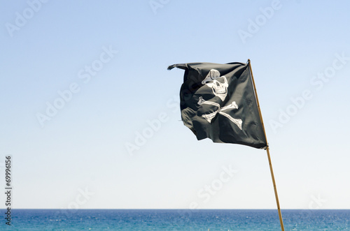 pirate flag waving with blue sea background
