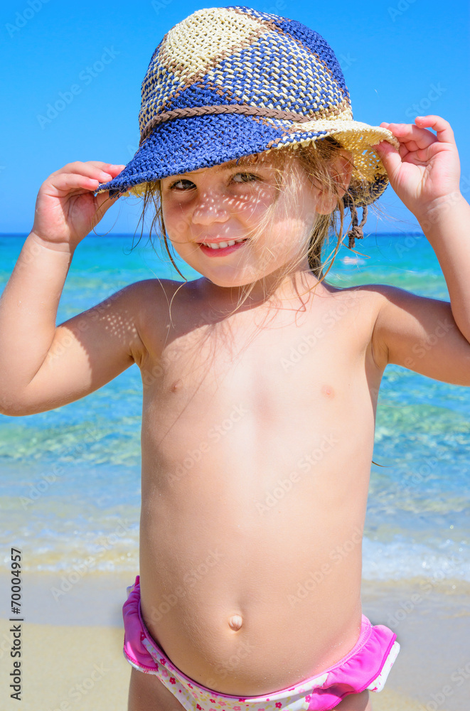 Bimba al mare con cappello blu Stock Photo | Adobe Stock