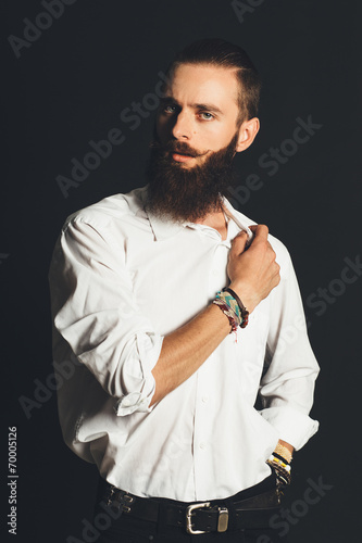 Young handsome man in white shirt on black background