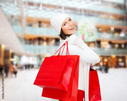 smiling young woman with red shopping bags