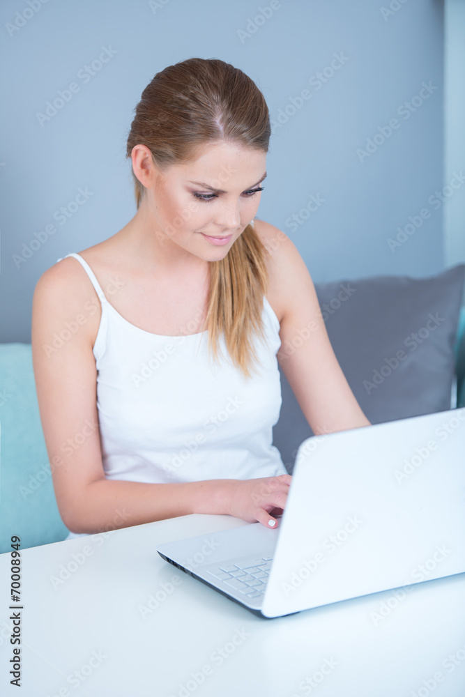 Attractive young woman using a laptop at home Attractive young woman using a laptop at home