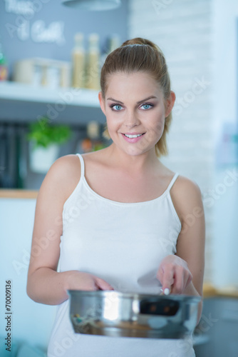 Attractive young woman cooking in the kitchen
