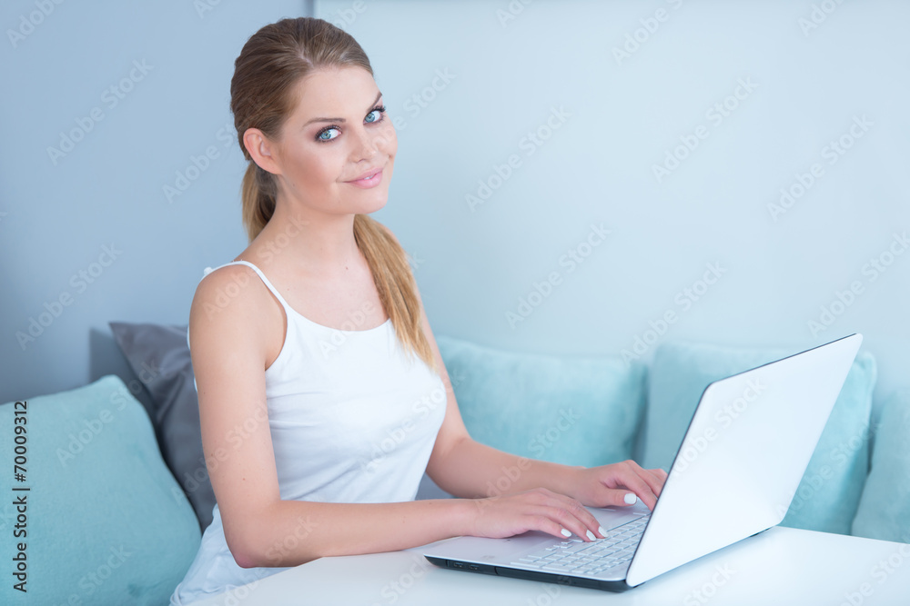 Attractive woman sitting using a laptop at home Attractive woman sitting using a laptop at home