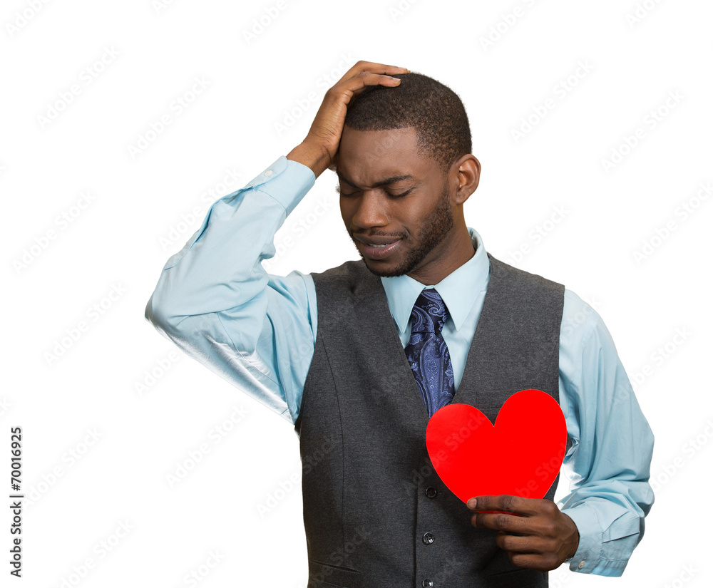 Heartbroken man, holding red heart in hand, white background Heartbroken man, holding red heart in hand, white background