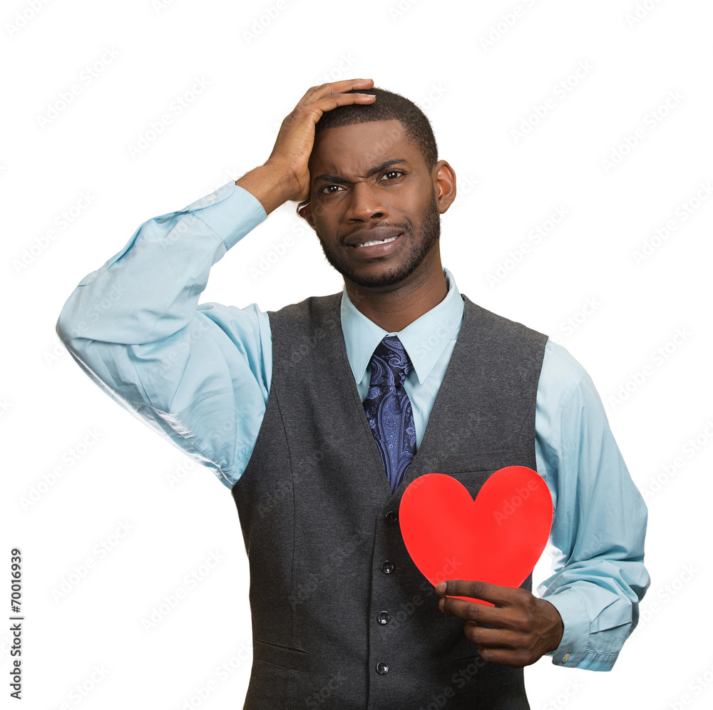 Heartbroken man, holding red heart in hand, white background Heartbroken man, holding red heart in hand, white background