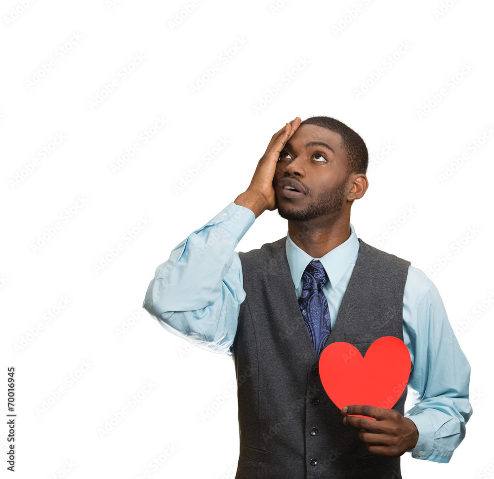 Heartbroken man, holding red heart in hand, white background 