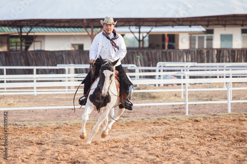 A cowboy riding a horse in his farm