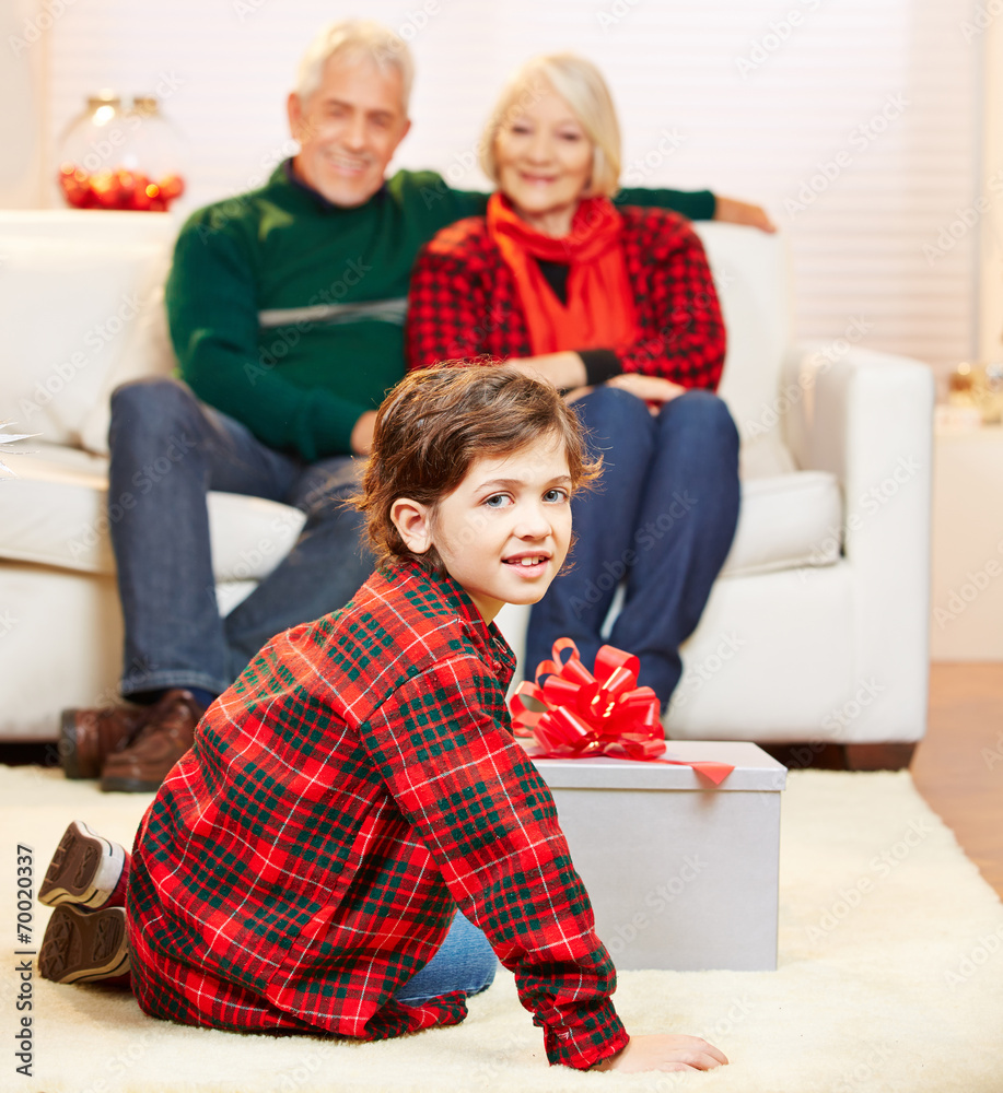 Sprüche Von Großeltern An Enkel Weihnachten Enkel öffnet Geschenk zu Weihnachten Stock Photo | Adobe Stock