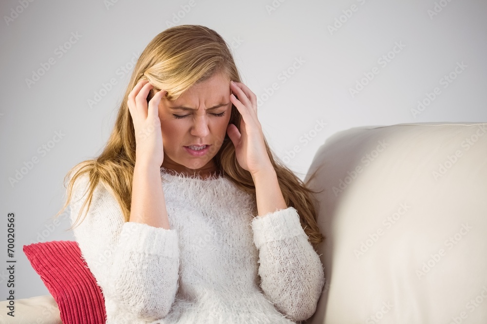 Pretty blonde getting a headache on the couch Pretty blonde getting a headache on the couch